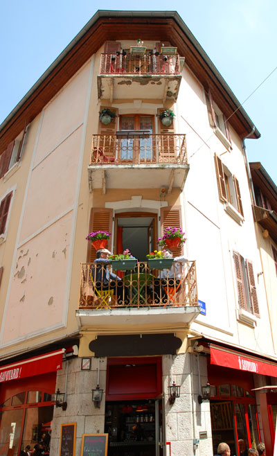 <Photo of residents in Annecy, France, lunching on the balcony on a spring day>