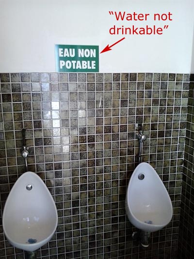 'Not drinking water' sign in French toilet.